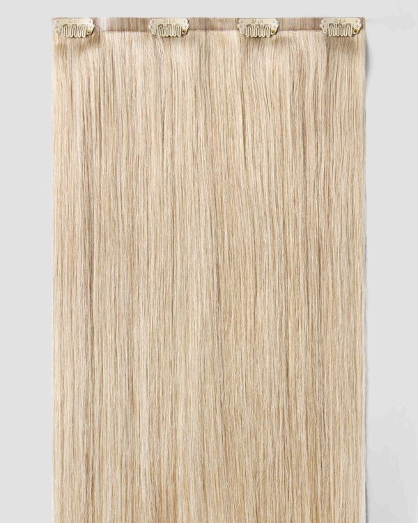 A champagne blonde clip-in hair extensions are displayed elegantly, showcasing their vibrant color and texture.