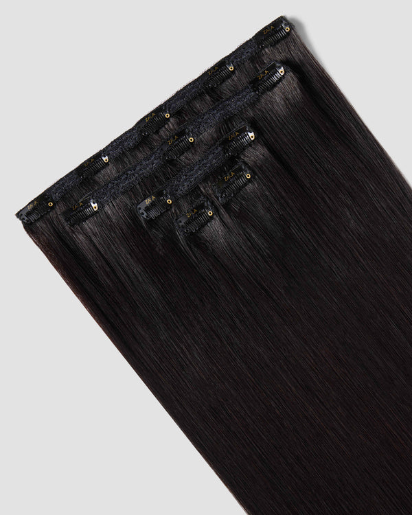 A 5 piece set of clip-in hair extensions in natural black, highlighting their clips and width.