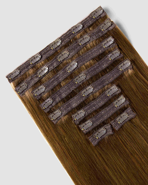 Clip-in chestnut brown hair extensions are displayed elegantly, showcasing their rich color and natural texture.