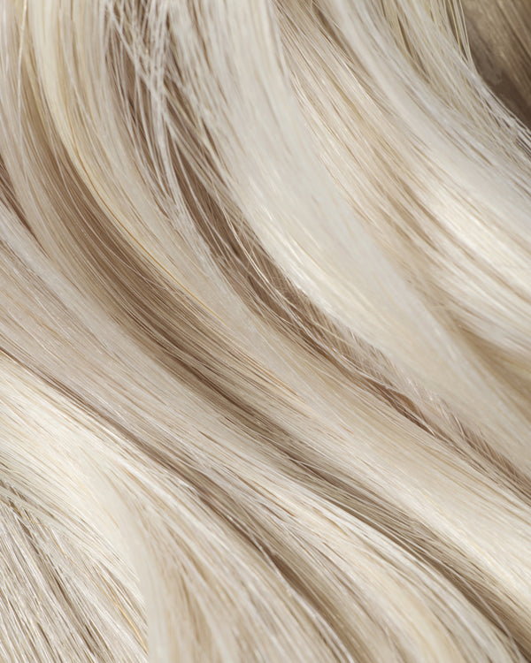 A close-up of long, ice queen platinum hair extensions, showcasing their luxurious shine and silky texture.