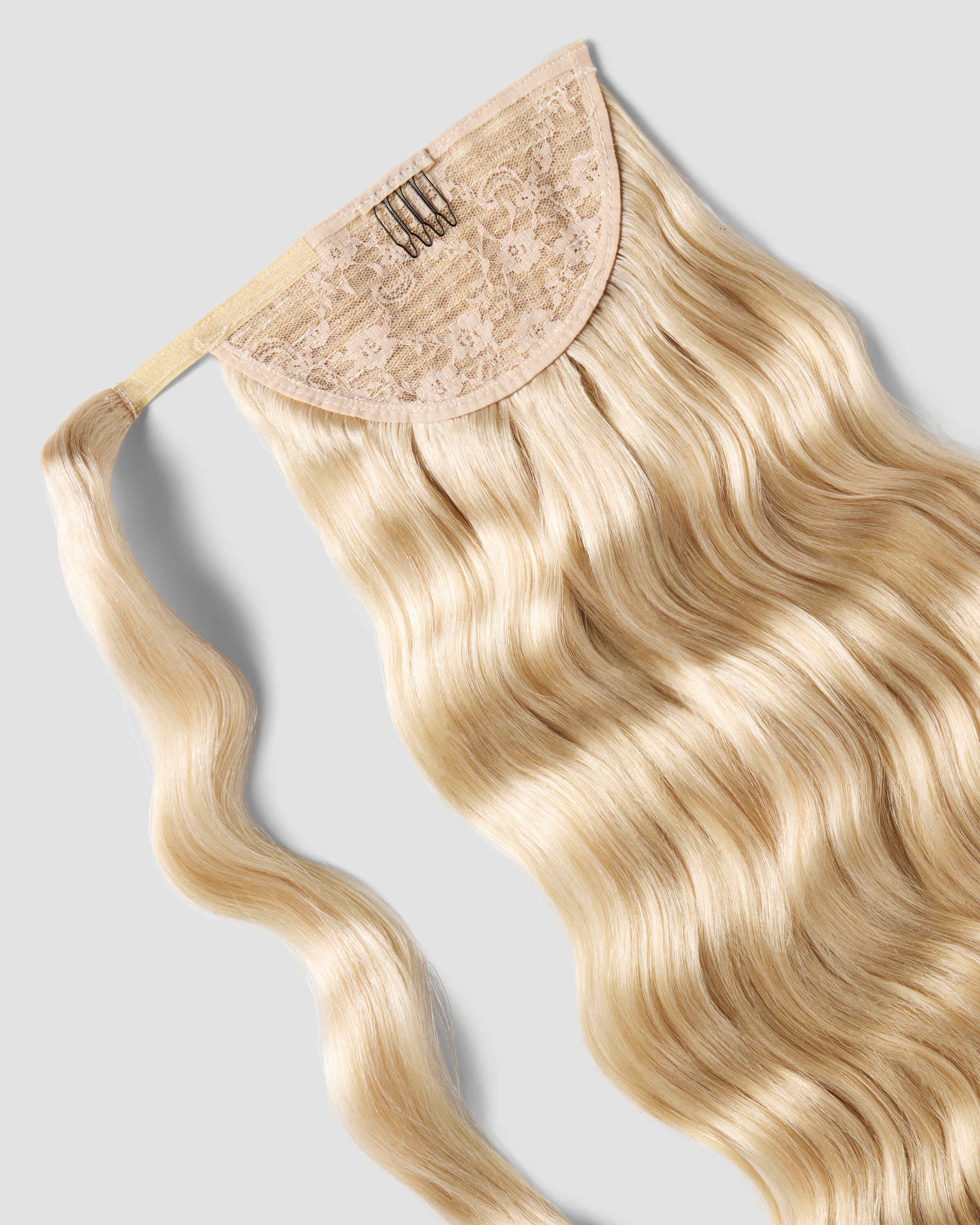 A beachy blonde clip-in hair extension featuring a curly ponytail, perfect for enhancing hairstyles with added flair.