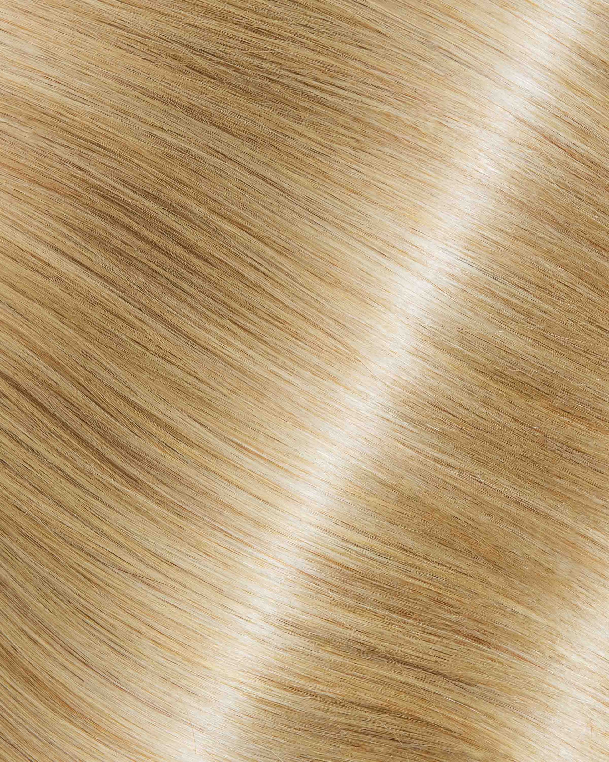 A detailed view of blonde hair texture featuring Iced Almond Latte extensions.