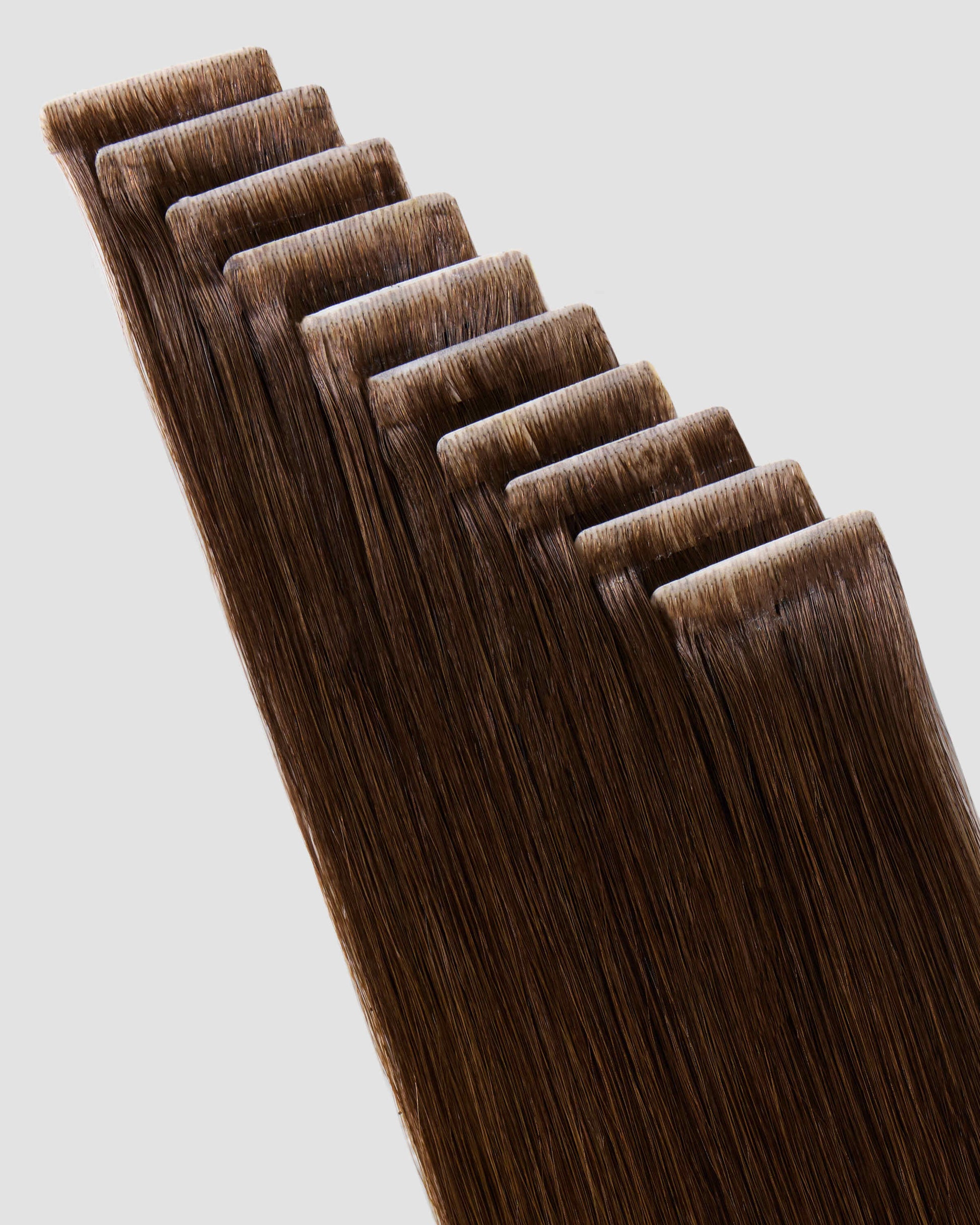 A collection of chestnut brown tape-in hair extensions displayed elegantly, showcasing their vibrant color and texture.