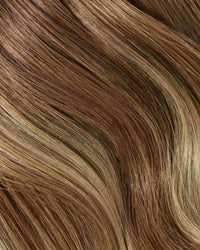 A close-up of hair showcasing blonde and brown highlights in a balayage style with Remy Hair Extensions.