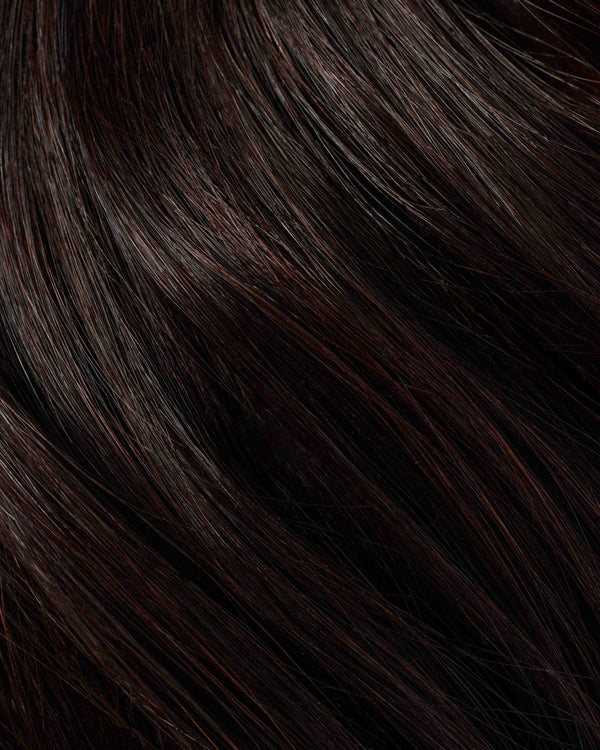 A detailed hair swatch of midnight brown hair extensions, highlighting the deep, dark brown hue.