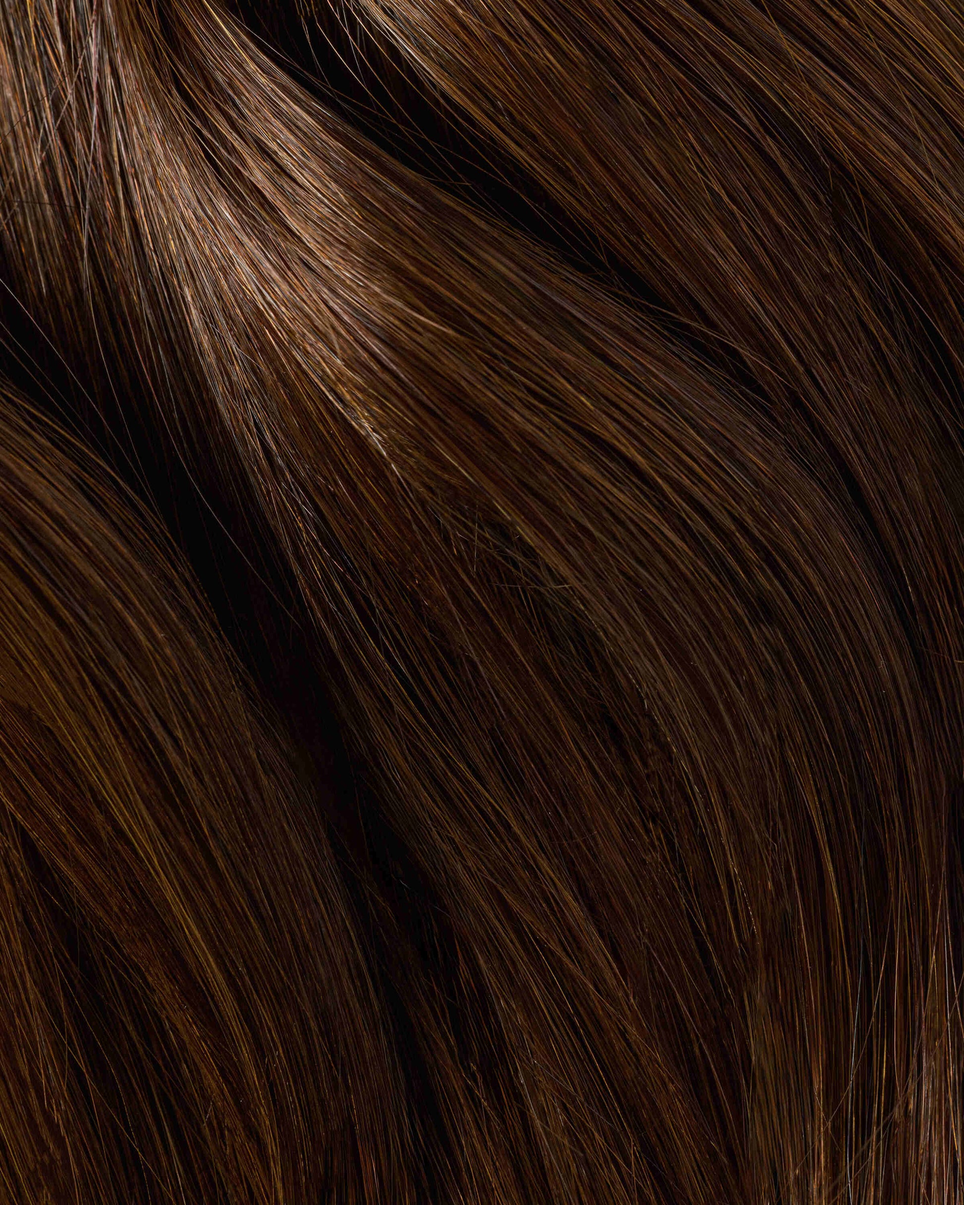 A detailed view of a brown hair swatch showing texture, highlighting the richness of a mocha colored hair extension.