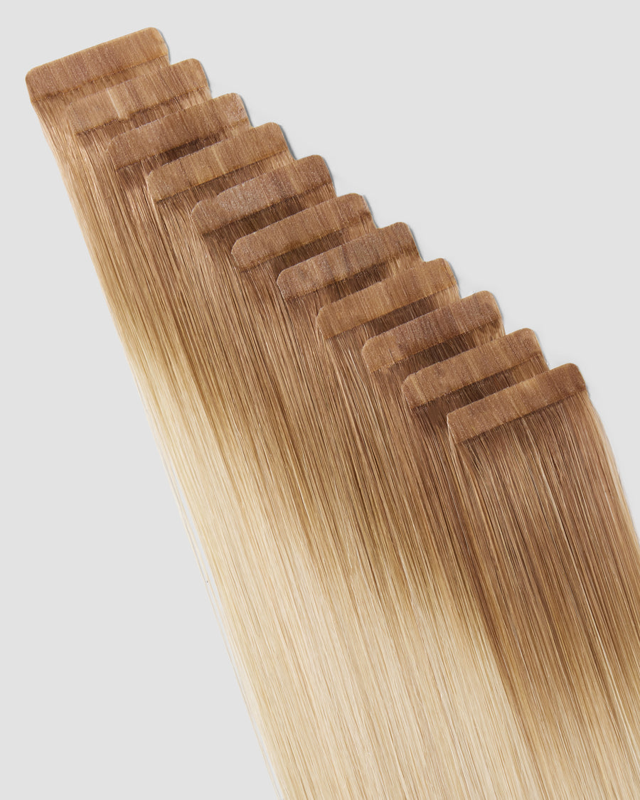 Tape-in hair extensions in a balayage cheesecake style showcasing a blend of light and dark tones.