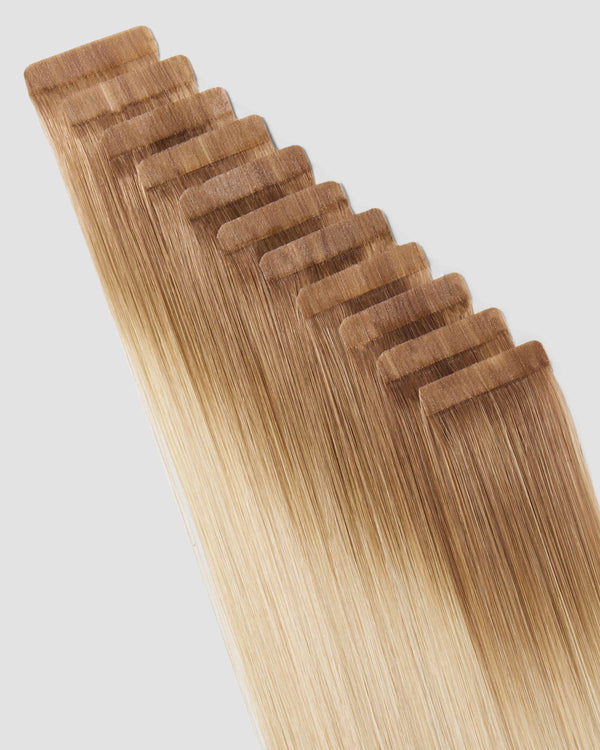 Tape-in hair extensions in a balayage cheesecake style showcasing a blend of light and dark tones.