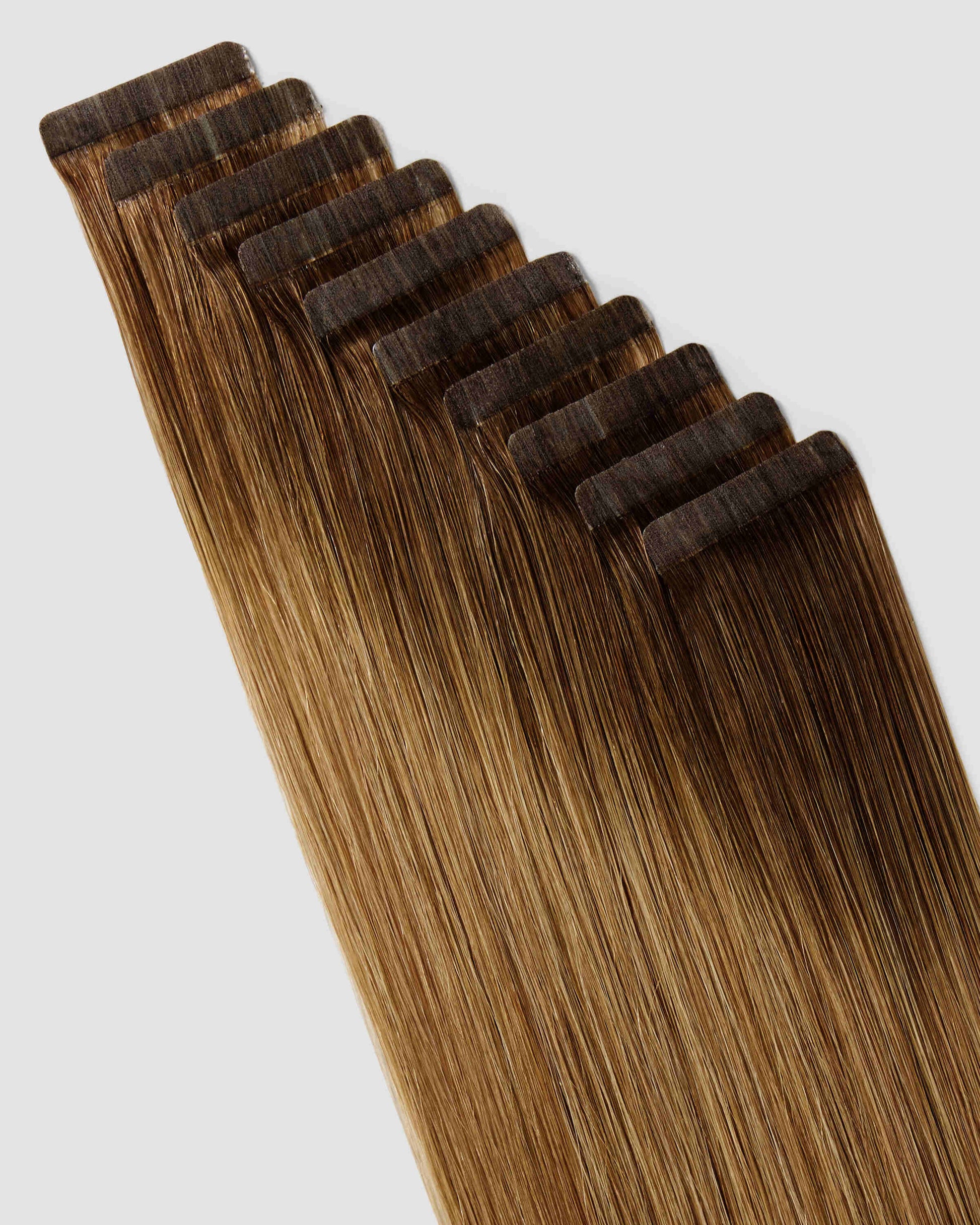 A close-up of chestnut dirty hair extensions showcasing a seamless ombre balayage effect.