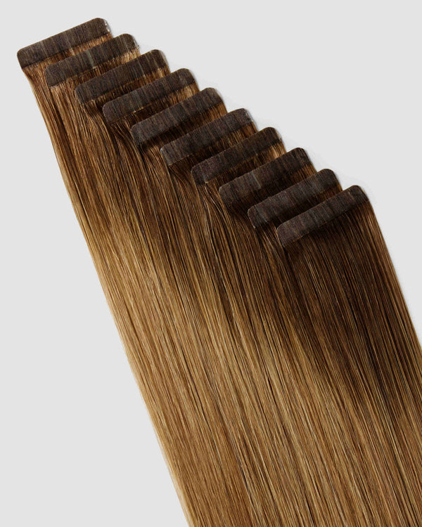 A close-up of chestnut dirty hair extensions showcasing a seamless ombre balayage effect.
