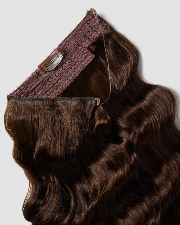 A halo hair extension in wavy dark chocolate, featuring a brown clip for long hair laying against a white background.