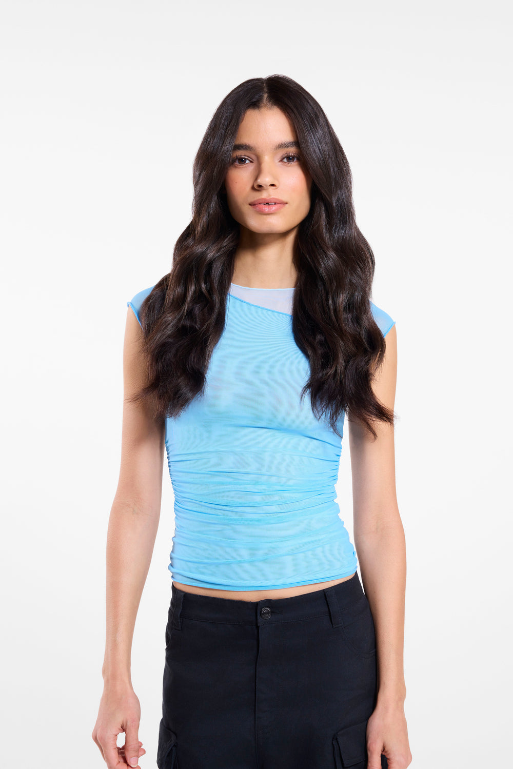 A model wearing a blue top and black pants showcases her hair after applying Zala hair extensions.