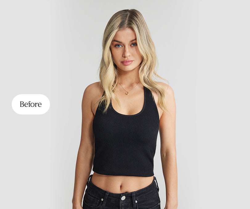 A woman dressed in a black crop top and jeans, displaying her natural hairstyle before hair extension application.