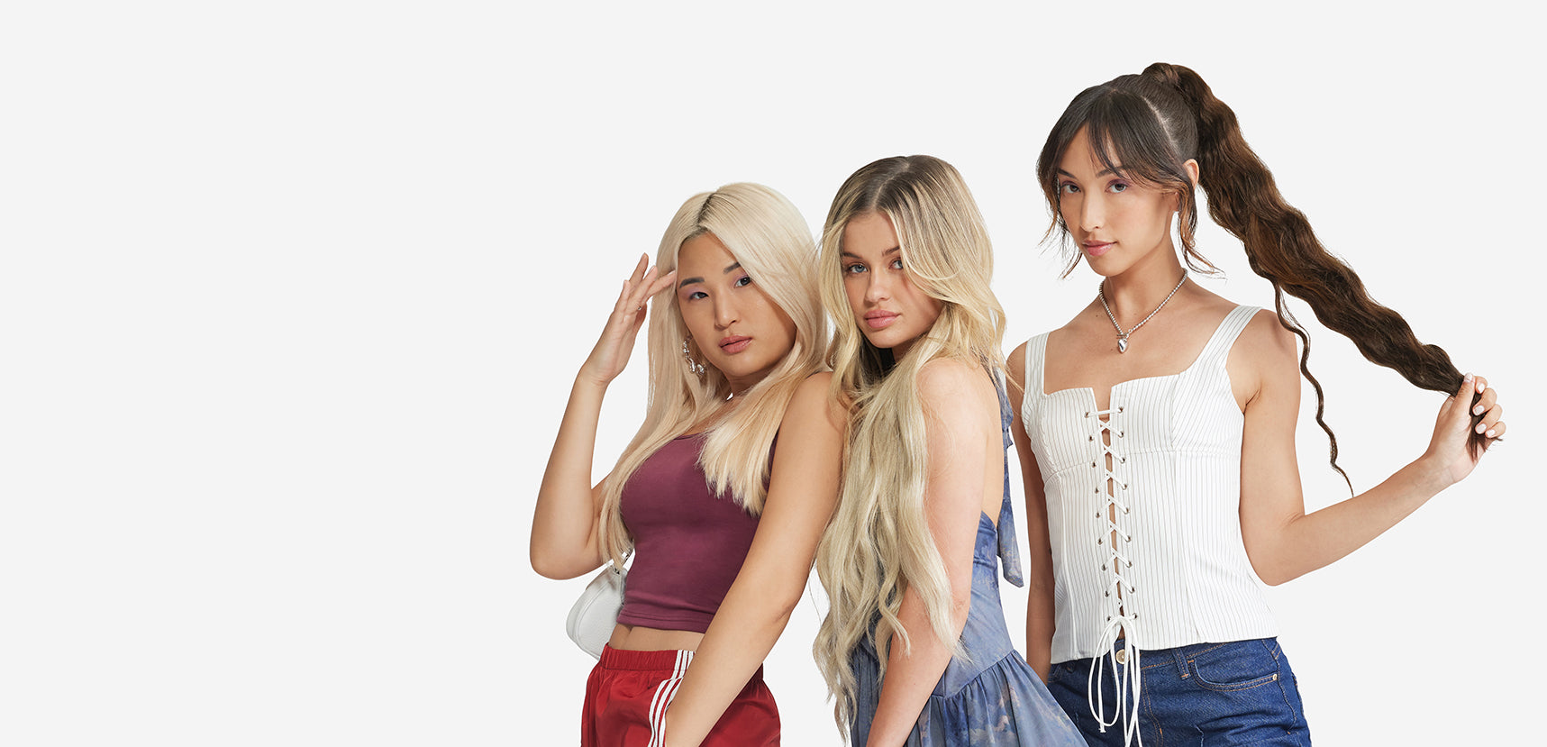 Three women pose for a photo, showcasing various styles of Zala hair extensions in different colors and lengths.