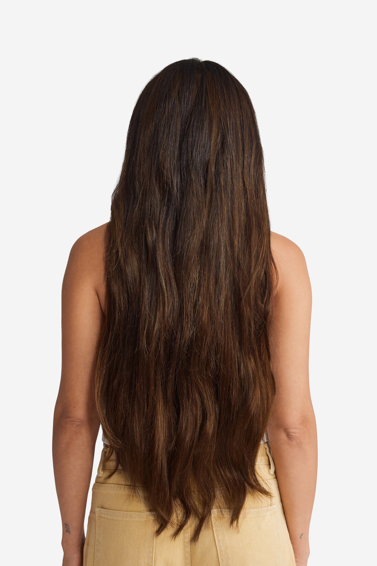 A back view of a woman with straight brown sugar hair extensions for added length and volume.