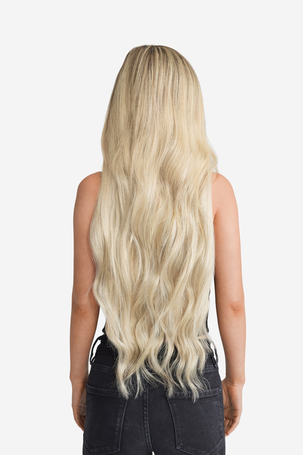 A back view of a woman with long blonde hair extension.