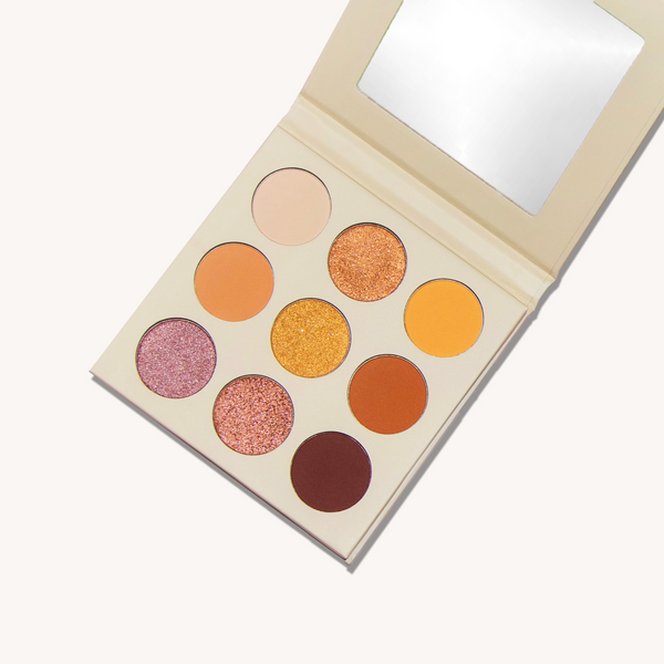 A white box containing a colorful palette of eyeshadow shades is arranged neatly.