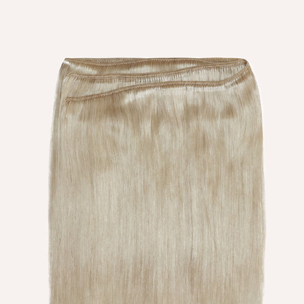A long blonde hair with a champagne weave displayed on a white background.