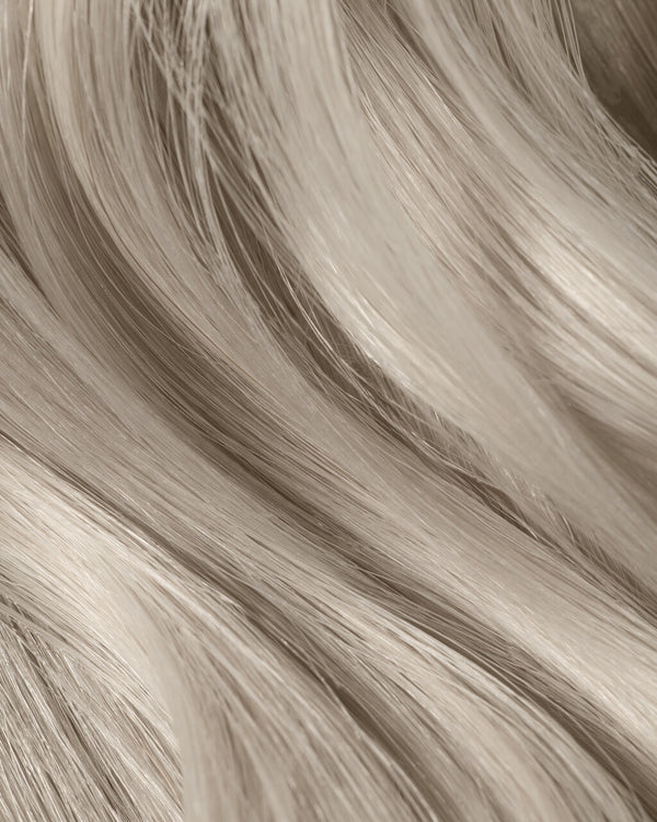 A close-up of long, ice queen platinum hair extensions, showcasing their luxurious shine and silky texture.