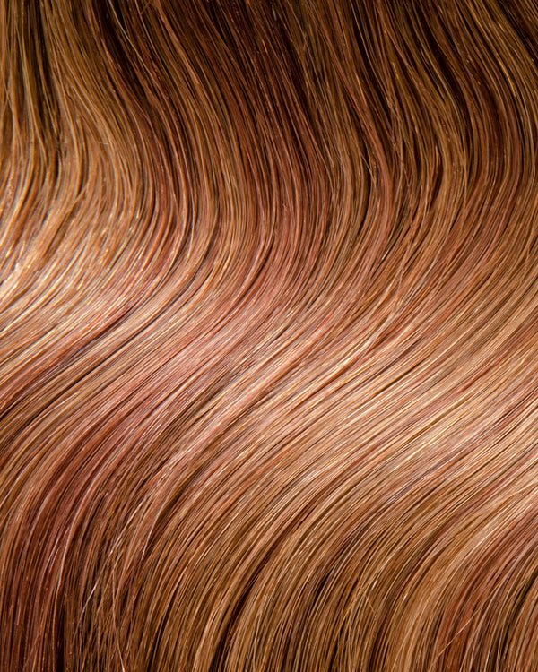 A hair extension swatch of a red shaded hair extension, showcasing a rich and textured appearance.