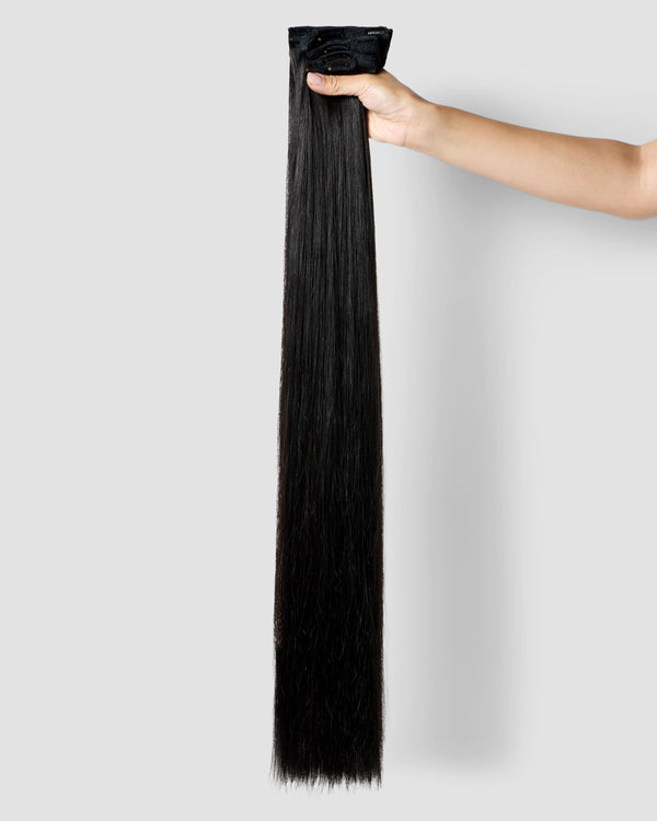 A set of clip-in hair extensions in natural black, highlighting their seamless design and rich, vibrant color.