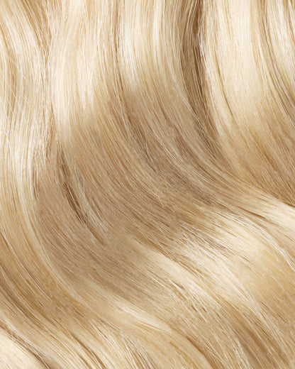 A swatch of beachy blonde hair featuring a mix of wavy and straight strands, showcasing its vibrant texture and style.