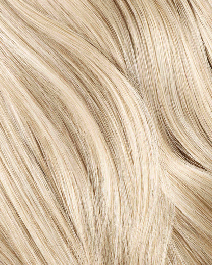 A swatch of a champagne blonde hair extension featuring wavy hair, showcasing its rich texture and vibrant color.