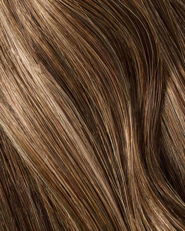 Detailed view of a hair swatch with snickers colored brown and blonde highlights, emphasizing the beauty of hair extensions.