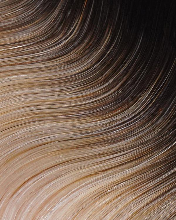 A swatch of hair featuring blonde and brown Ombré, showcasing the texture and shine of hair extensions.