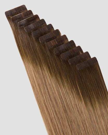 A set of natural hair extensions in Balayage Toffee Blonde, designed for easy tape-in application.