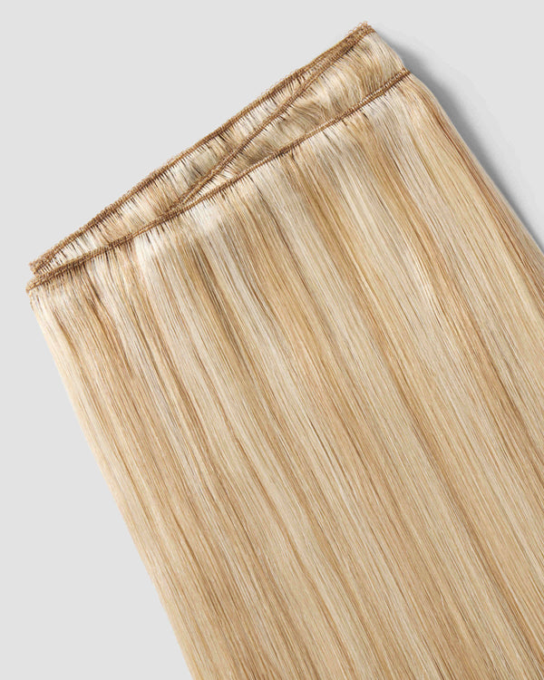 A detailed view of a honey beach weft hair extension, highlighting the weave-in design for a natural look.