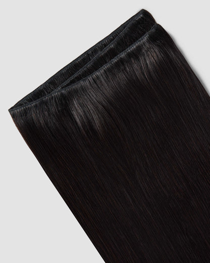 A black hair extension on a white background, highlighting its natural weave and elegant appearance. 