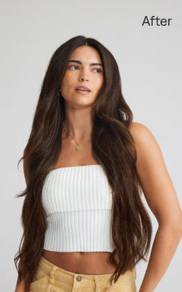 A woman with long hair after styling, showcasing the transformation with hair extensions applied.