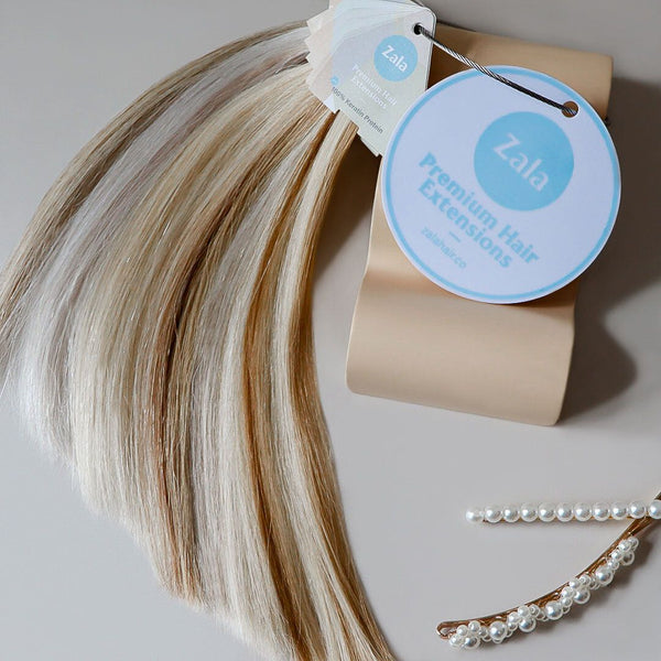 A color swatch ring of Zala premium hair extensions featuring a label showcasing various colors available for purchase.