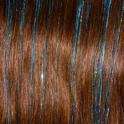 A swatch of hair featuring tinsel blue extensions adorned with shimmering blue and green sparkles.