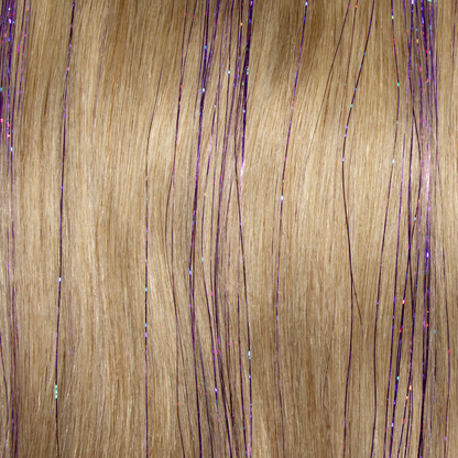 A close-up of long blonde hair featuring purple and gold strands, enhanced with tinsel purple hair extensions.